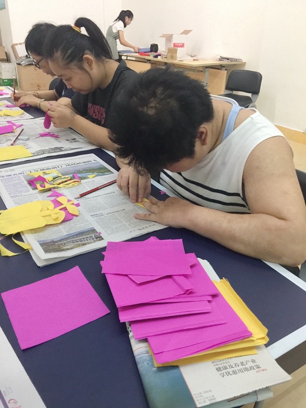 图为广州市越秀区残疾人剪纸培训班现场，学员正在认真折纸.JPG